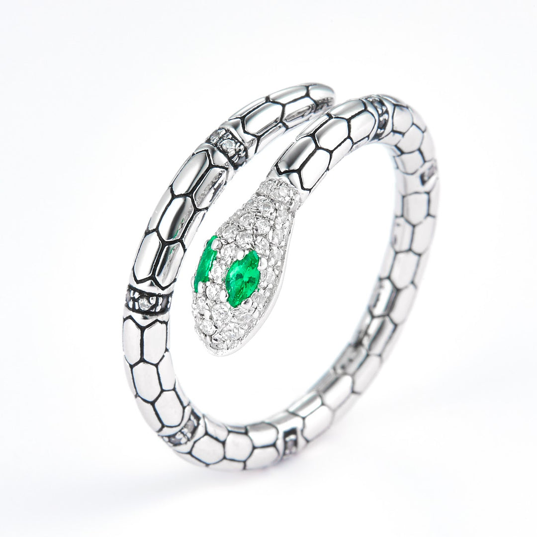 a ring with snake design with green stone eyes